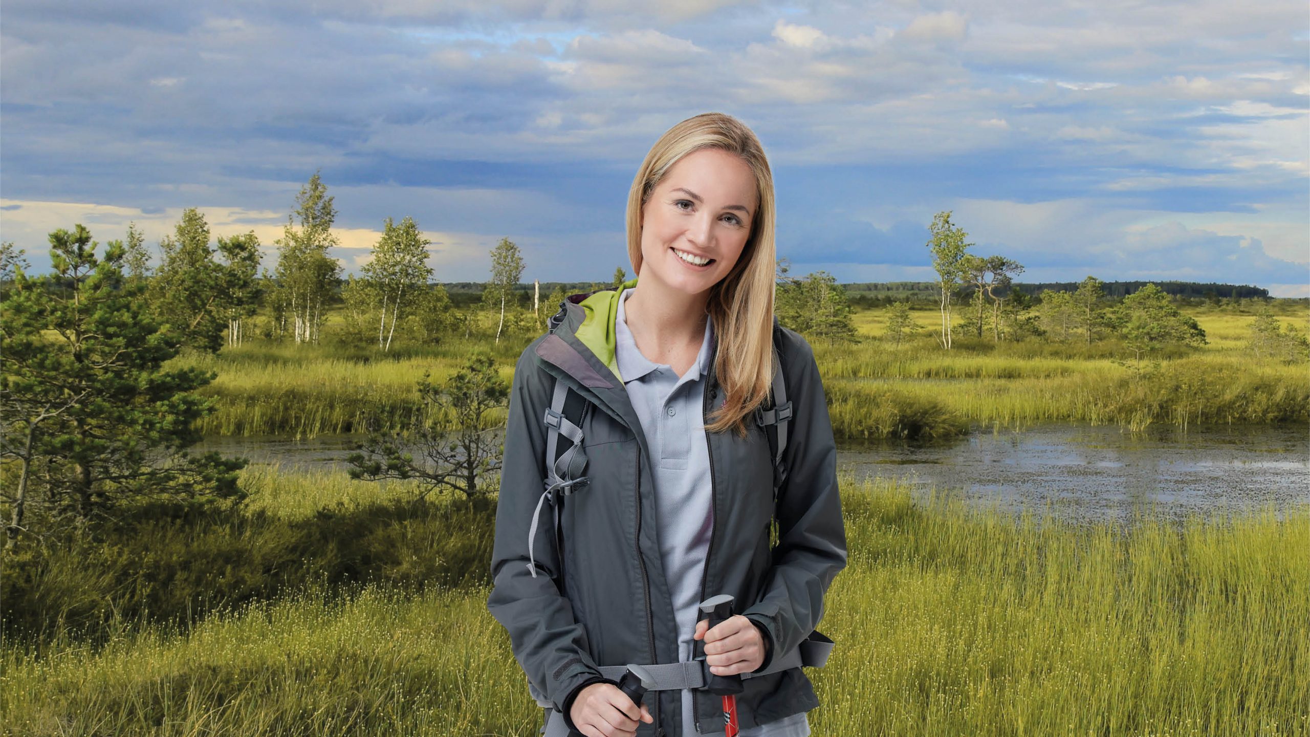 Junge Frau mit Gehstöcken im Vordergrund, im Hintergrund Naturwiese und See