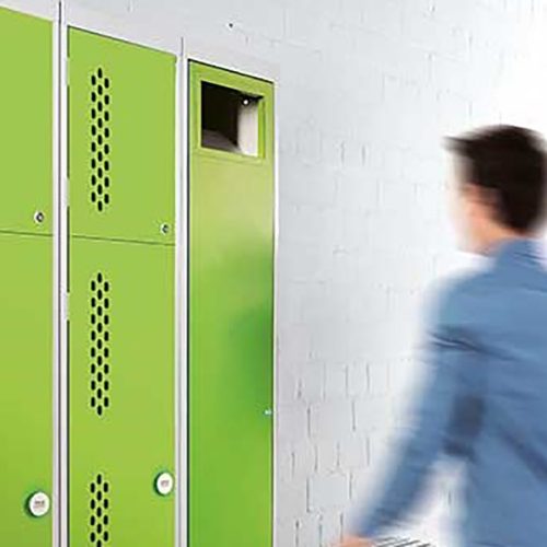 Mann in blauem Hemd geht auf grünen Kombi-Schrank zu