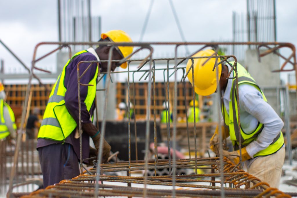 Zwei Handwerker mit Bauhelm und Warnschutzwesten